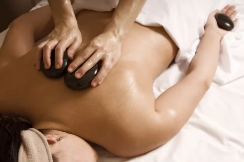 Therapist giving a hot stone massage to client